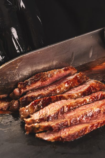 Juicy freshly grilled steak. chef cuts fried meat to slices